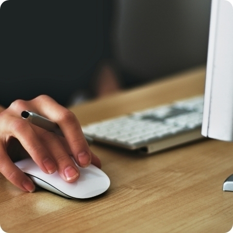 hand on a mouse next to a keyboard